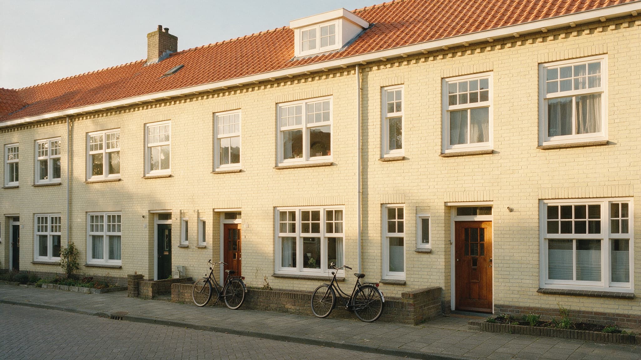 Een warme Nederlandse straat met jaren-30 rijwoningen